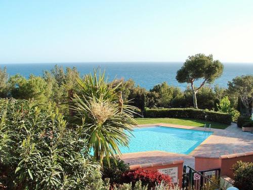 une piscine avec l'océan en arrière-plan dans l'établissement Résidence avec piscine, vue mer, tennis, parc pour enfants, à Saint-Mandrier-sur-Mer
