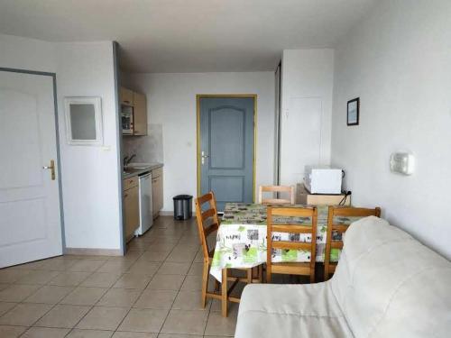 a living room with a table and chairs and a kitchen at Résidence Gardette - Studio pour 4 Personnes 504 in Réallon