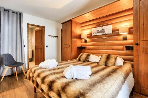 a bedroom with a large bed with two towels at Résidence Les Arcs Le Village - maeva Home - Appartement pièces - Prestige 711 in Arc 1950