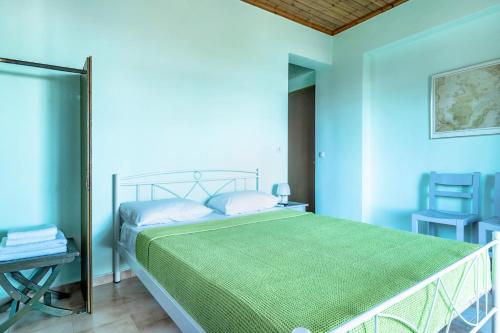 a bedroom with a bed with a green blanket at Old Boat double studio 11 in Nikiana