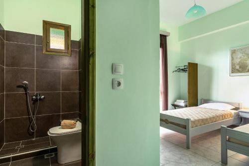 Un baño con inodoro y una cama en una habitación. en Old Boat double studio 6, en Nikiana