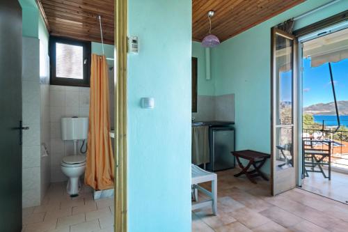 baño con aseo y balcón en Old Boat double studio 10, en Nikiana