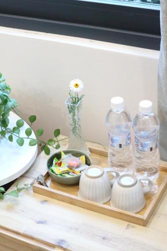 a tray with bottles of water and a bowl of food at La Verne Homestay Dalat in Da Lat