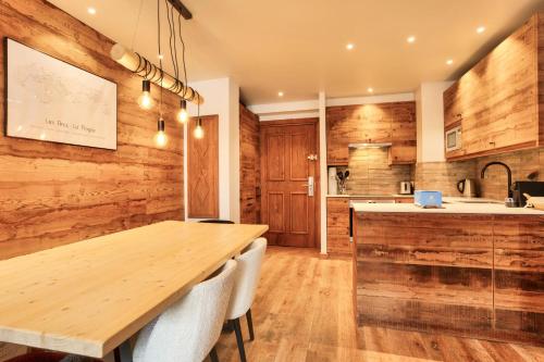 a kitchen with wooden walls and a wooden table and chairs at Résidence Les Arcs Le Village - maeva Home - Duplex pièces - Exclusive 721 in Arc 1950