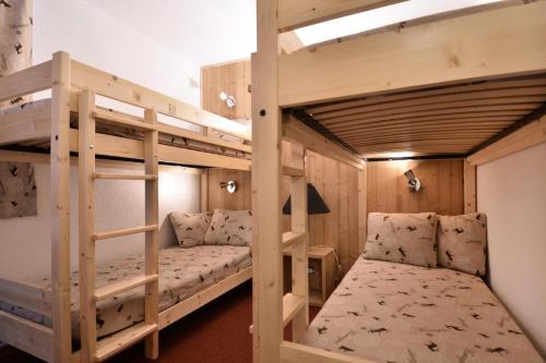 een slaapkamer met 2 stapelbedden en een bank bij Résidence Carroley B - 2 Pièces pour 5 Personnes 97 in Mâcot La Plagne