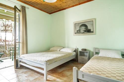 a bedroom with two twin beds and a balcony at Old Boat double studio 8 in Nikiana