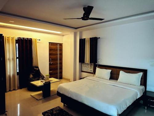 a bedroom with a large bed with a ceiling fan at Hotel Pink Paradise in Gorakhpur