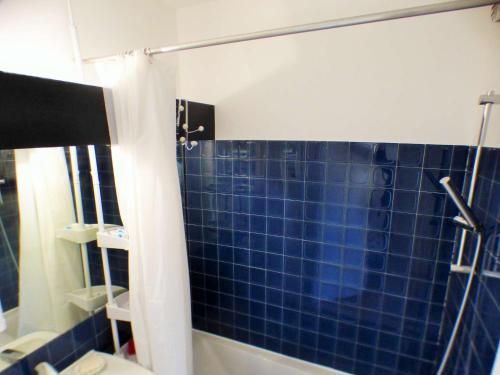 La salle de bains est pourvue d'une douche avec du carrelage bleu sur le mur. dans l'établissement Superbe vue mer, au dernier étage avec ascenseur, résidence avec piscine, à La Seyne-sur-Mer