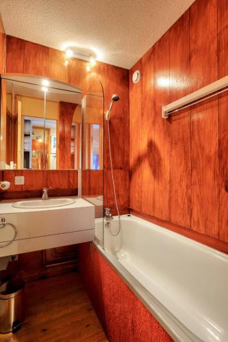 une salle de bain avec un lavabo, une baignoire et un miroir dans l'établissement Quartier Crève Cœur - maeva Home - Studio 4 Personnes - Confort MAE-3811, à Valmorel