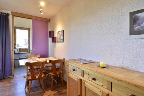 a dining room with a wooden table and chairs at Résidence Beryl - Studio pour 4 Personnes 10 in Mâcot La Plagne
