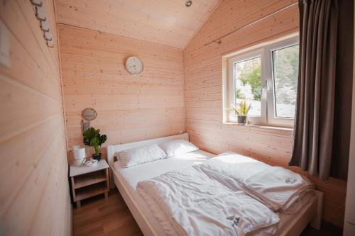 niewielka sypialnia z łóżkiem i oknem w obiekcie Siedlisko13 w mieście Mrągowo