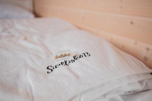 a close up of a bed with a white blanket at Siedlisko13 in Mrągowo