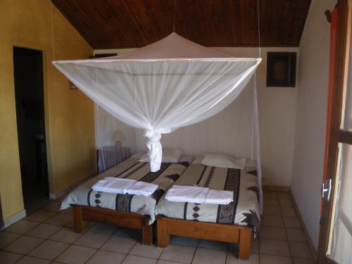 a bedroom with a bed with a canopy at Manga Lodge in Andavadoaka