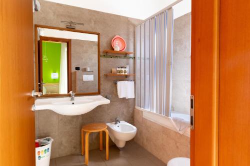 La salle de bains est pourvue d'un lavabo, de toilettes et d'un miroir. dans l'établissement Marini Hotel B&B, à Lido Marini