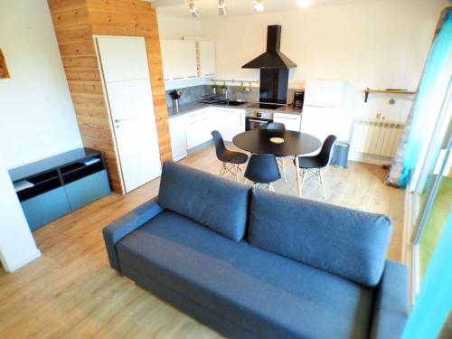 un salon avec un canapé bleu et une table dans l'établissement Appartement refait à neuf, résidence avec piscine à Saint Mandrier village, à Saint-Mandrier-sur-Mer