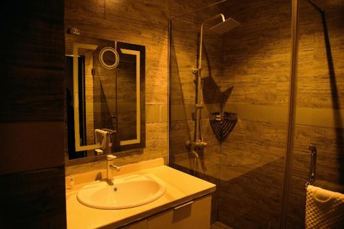a bathroom with a sink and a shower at WosAm Hotels in Ago Iwoye