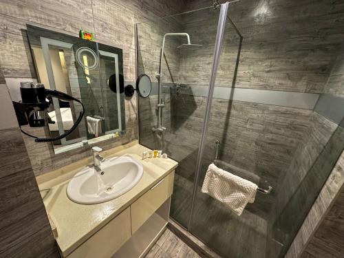 W łazience znajduje się umywalka i przeszklony prysznic. w obiekcie WosAm Hotels w mieście Ago Iwoye