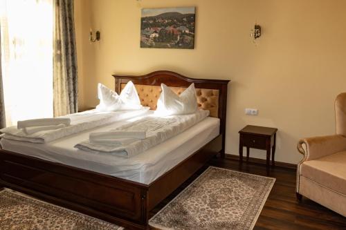 um quarto com uma cama grande e lençóis brancos em Melik em Borsec