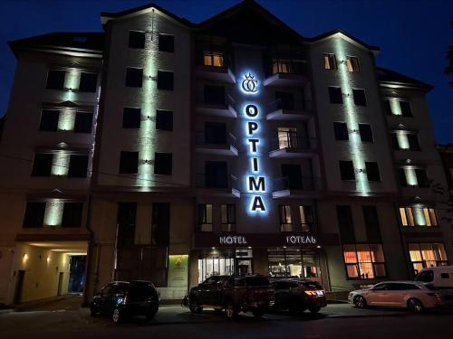 a hotel with cars parked in front of it at night at Optima Collection Troitska in Dnipro