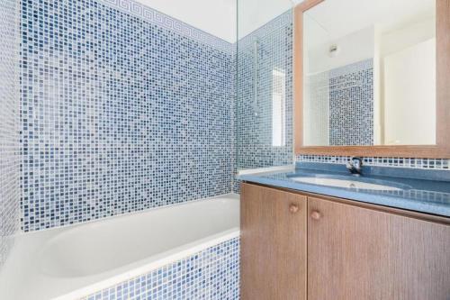 une salle de bain avec une baignoire, un lavabo et un miroir dans l'établissement Résidence le Hameau de Cap Esterel - maeva Home - Appartement 2 Pièces 5 Personnes - Confort MAE-1126, à Saint-Raphaël