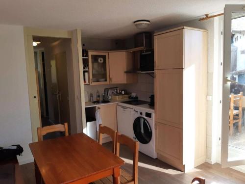 a kitchen with a table and a refrigerator and a stove at Résidence Ecrin - Pièces 944 in Vénosc