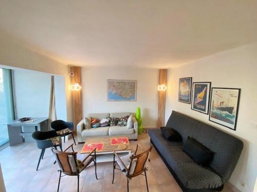 un salon avec un canapé et une table dans l'établissement Bel appartement avec jardin à seulement 50 m de la plage et de Sanary.Climatisation, à Six-Fours-les-Plages