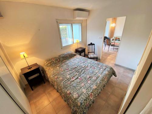 1 dormitorio con 1 cama y 1 mesa con lámpara en Bel appartement avec jardin à seulement 50 m de la plage et de Sanary.Climatisation, en Six-Fours-les-Plages