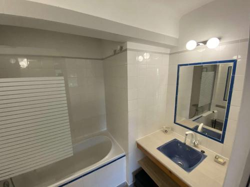 une salle de bain avec un lavabo, une baignoire et un miroir dans l'établissement Bel appartement avec jardin à seulement 50 m de la plage et de Sanary.Climatisation, à Six-Fours-les-Plages