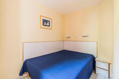- une chambre avec un lit bleu dans l'établissement Résidence le Hameau de Cap Esterel - maeva Home - Appartement 2 Pièces 5 Personnes - Sélection MAE-1144, à Saint-Raphaël