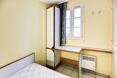 une petite pièce avec un lit et une fenêtre dans l'établissement Résidence Port du Crouesty - maeva Home - Appartement 2 pièces 5 personnes - Sélection MAE-1186, à Arzon