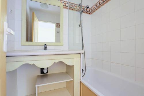 une salle de bain avec un lavabo, un miroir et une baignoire dans l'établissement Les Issambres Bellevue - maeva Home - 2 Pièces 5 Personnes Budget MAE-1206, aux Issambres