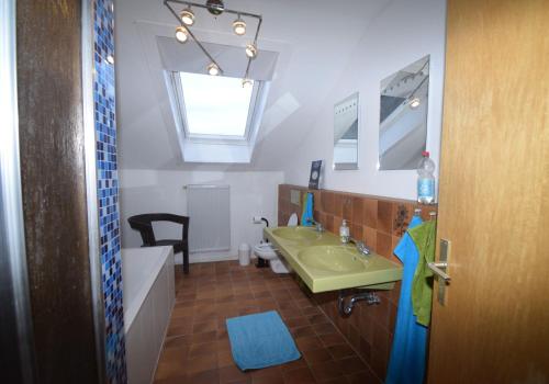 een badkamer met een groene wastafel en een bad bij Ferienunterkünfte maucher Immobilien in Buchenberg