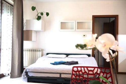 a bedroom with a bed and a red chair at [Monza] Monolocale completo in Monza