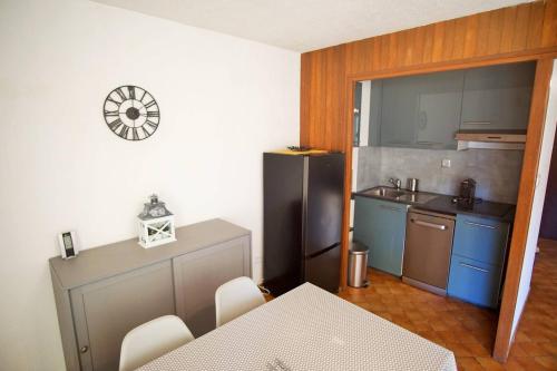 une petite cuisine avec une table et un réfrigérateur dans l'établissement Appartement 4 couchages à 100 M de la Plage, à Saint-Elme