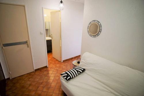 Sofá blanco en una habitación con espejo en Appartement 4 couchages à 100 M de la Plage en Saint-Elme