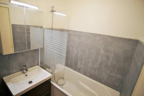 Appartement 4 couchages à 100 M de la Plage في Saint-Elme: حمام مع دش ومغسلة وحوض استحمام
