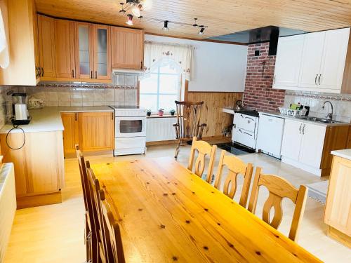 a kitchen with a wooden table and a kitchen with white appliances at Lillstugan Sälen by in Sälen