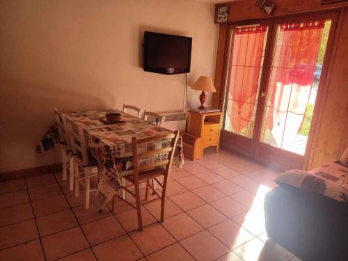 a dining room with a table and chairs and a television at Chalets D Or - 2 Pièces pour 4 Personnes 164 in Vénosc