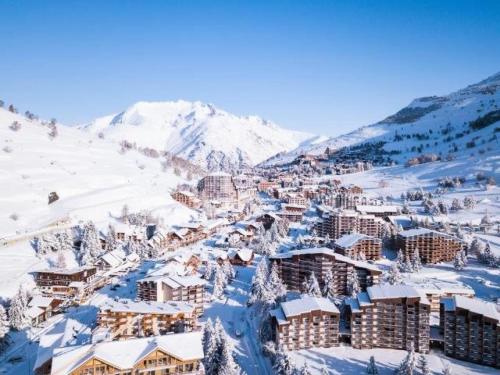 a town covered in snow with a mountain in the background at Chalets D Or - 2 Pièces pour 4 Personnes 164 in Vénosc