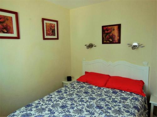 - une chambre dotée d'un lit avec des oreillers et des photos rouges dans l'établissement Village Pont Royal en Provence - maeva Home - Appartement 2 Pièces 5 Personnes Sélection MAE-1244, à Mallemort