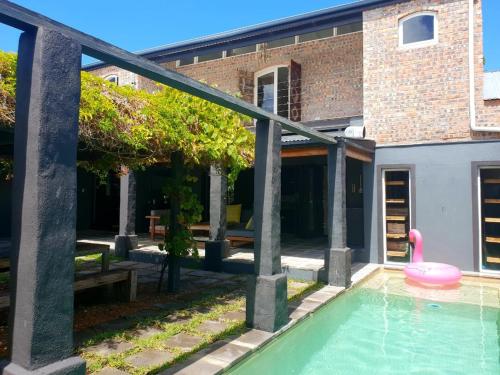 una casa con una piscina con un juguete rosa. en CLEMENT ONE, a villa for family & friends en Ciudad del Cabo