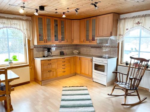 cocina con armarios de madera y horno de fogón blanco en Lillstugan Sälen by, en Sälen