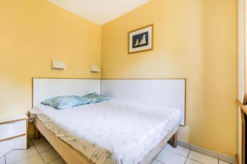 Ce lit se trouve dans un dortoir aux murs jaunes. dans l'établissement Résidence le Hameau de Cap Esterel - maeva Home - Appartement 2 Pièces 5 Personnes - Confort MAE-1268, à Saint-Raphaël