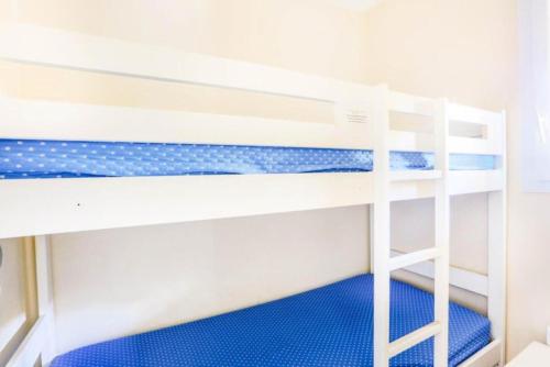 - une chambre avec 2 lits superposés et des sols bleus dans l'établissement Résidence le Hameau des Issambres - maeva Home - 2 Pièces 6 Personnes Sélection MAE-1295, aux Issambres