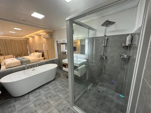 uma casa de banho com um chuveiro, uma banheira e um lavatório. em Luckytito Anilao Resort em Mabini