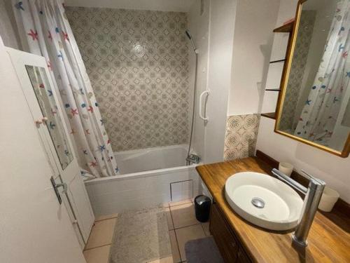 une salle de bain avec un lavabo et une baignoire dans l'établissement Piscine, Wi-Fi, parking privatif, terrasse, plages et commerces à pied, à Saint-Mandrier-sur-Mer