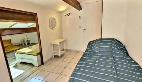 1 dormitorio con 2 literas y espejo en Pavillon avec un jardin à 100m de la plage, en Valras-Plage