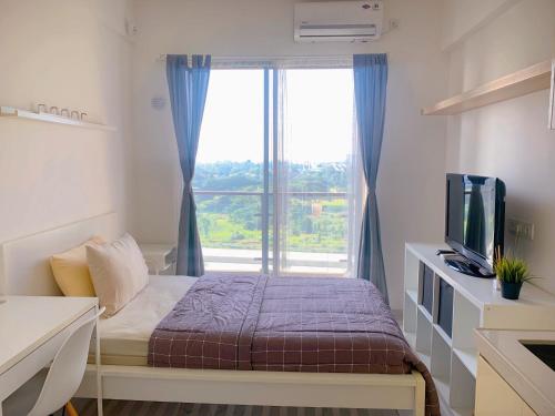 a bedroom with a bed and a large window at Apartemen Sky House BSD by Benchmark in Tangerang