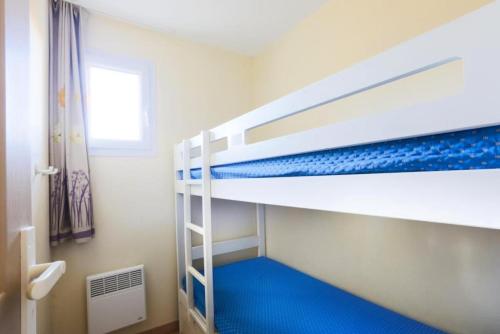 - une chambre avec 2 lits superposés et un sol bleu dans l'établissement Résidence le Hameau des Issambres - maeva Home - 2 Pièces 6 Personnes Sélection MAE-1296, aux Issambres