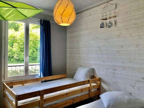 Habitación con cama de madera y ventana en Sur la plage le bonheur en Plestin-les-Grèves